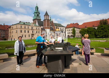 Tourists visit the model of the castle with the real Wawel Royal Castle behind on Wawel Hill, Krakow, Poland in September Stock Photo