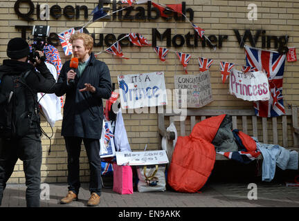 London, UK. 30th Apr, 2015. Journalists report from the 'Queen Mother Wing' at St. Mary's Hospital, where royals fans await Prince William and Kate's second baby, in London, England, 30 April 2015. Royalists have decorated the spot with numerous British flags. Photo: JENS KALAENE/dpa/Alamy Live News Stock Photo