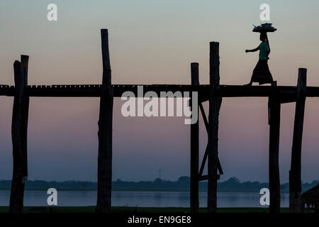 People crossing wooden bridge at sunset, U- bein bridge, Mandalay, Myanmar. Stock Photo