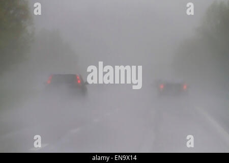 View of vehicles on the freeway driving through dangerous, wet and low vvisibility weather conditions Stock Photo