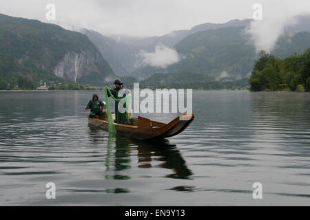 fishermen on a Plaette boat on a rainy morning at Grundlsee, Styria, Austria Stock Photo