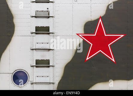 A large fragment of the old Soviet military helicopter. Red Star on board, ladder and round window. Stock Photo