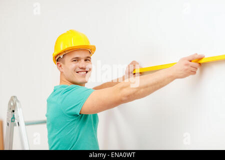 smiling man building using spirit level to measure Stock Photo