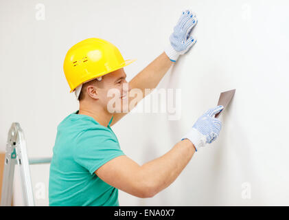 smiling man in helmet doing renovations at home Stock Photo