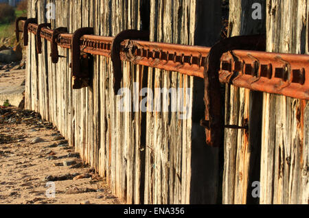 Recycled railway sleepers and rail tracks to make a sea defense wall old technology. New problems Stock Photo