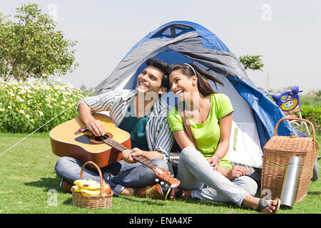 2 indian Married couples park Picnic Singing Guitar Stock Photo