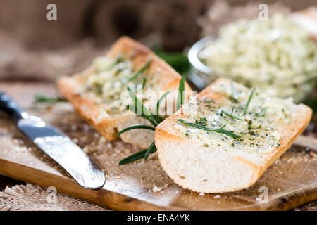 Baguette with Herb Butter and Rosemary on rustic wooden background Stock Photo