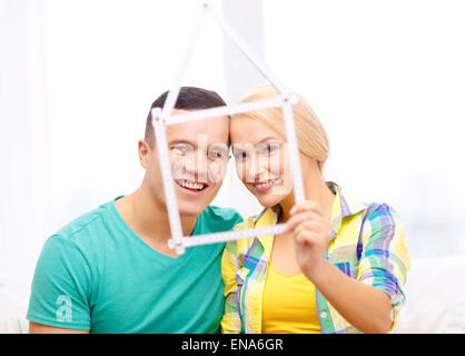 smiling couple with house from measuring tape Stock Photo