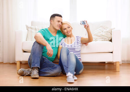 smiling couple taking picture with digital camera Stock Photo