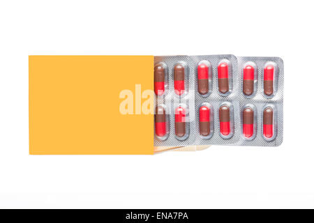 Yellow box with red pills in a blister pack on an isolated background Stock Photo