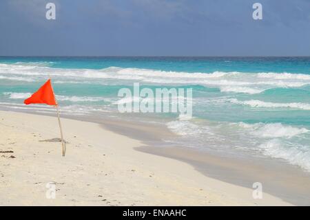 Red flag for swimming set on the Caribbean shore Stock Photo