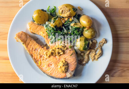 Grilled salmon steak with new baby potatoes and spinach and horseradish Stock Photo