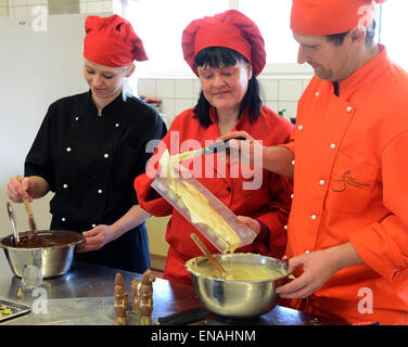 Oldisleben, Germany. 10th Apr, 2015. Company boss, Karin Finger (C), head chef, Marko Schnitter, and chef, Viktoria Steinwachs, prepare various chocolates for pralines and edible high heels in the Goethe Chocolate Factory in Oldisleben, Germany, 10 April 2015. The colorful high-heeled shoes are part of the extensive, high-quality praline production at her company, which was founded ten years ago. Photo: WALTRAUD GRUBITZSCH/dpa/Alamy Live News Stock Photo