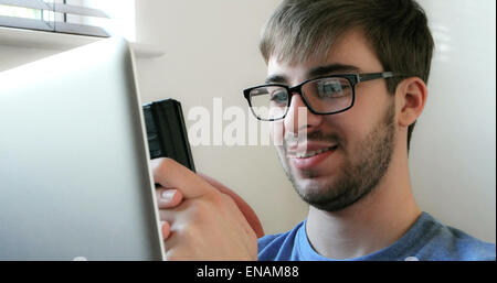 Young man using a phone and laptop. Stock Photo