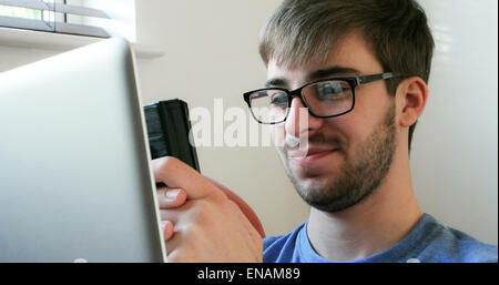 Young man using a phone and laptop. Stock Photo