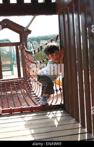 Young boy plays on a jungle Gym Stock Photo