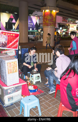 dh Fortuneteller CAUSEWAY BAY HONG KONG Chinese fortune teller woman shoe banging foretelling couples future Stock Photo