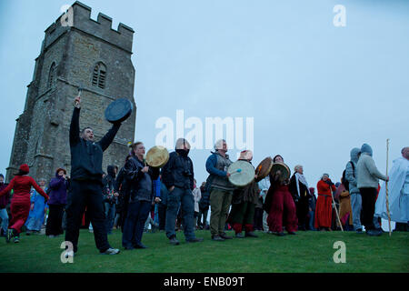 Goddesses, Druids, Pagan worshippers and Morris dancers begin a day of  Beltane Celebrations at sunrise on Glastonbury Tor. Stock Photo