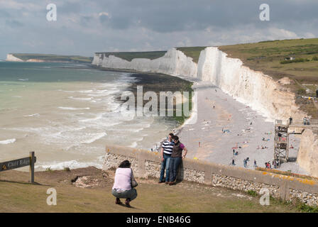 Two people have their picture taken at Birling Gap East Sussex UK Stock Photo