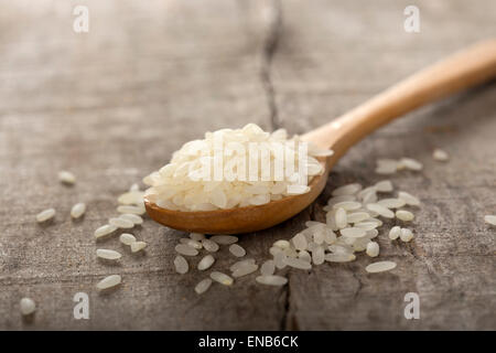 Close up of some rice in wooden spoon on wood background Stock Photo