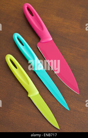 Set of large and small serrated kitchen knives color on a wooden board Stock Photo