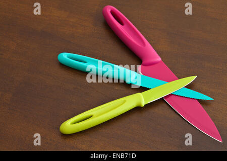Set of large and small serrated kitchen knives color on a wooden board Stock Photo