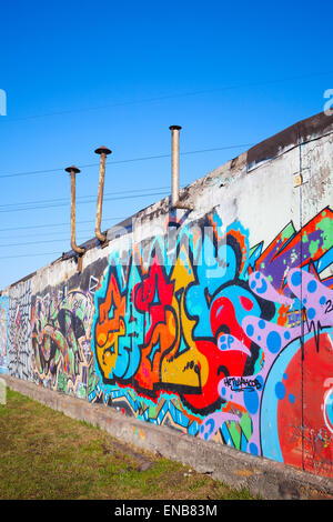 Saint-Petersburg, Russia - April 6, 2015: Colorful abstract graffiti painted on old gray concrete garage walls. Vertical photo Stock Photo