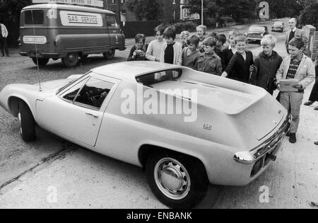 Manchester United footballer George Best surrounded by young fans as he drives away in his new yellow Lotus Europa car. Circa August 1969. Stock Photo