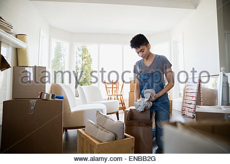 Woman packing belongings in moving boxes