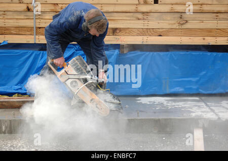 Builder cuts edge of concrete slab with diamond saw blade concrete cutter Stock Photo