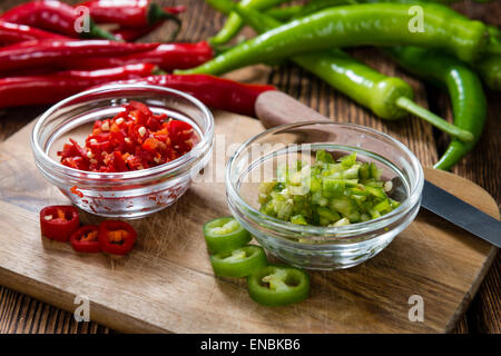 Mixed cutted Chilis (red and green) on vintage wooden background Stock Photo