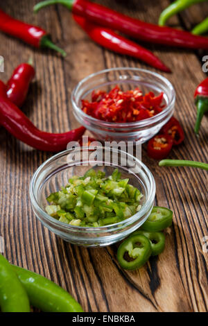 Mixed cutted Chilis (red and green) on vintage wooden background Stock Photo