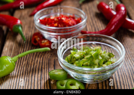 Red and Green Chilis (cutted) on wooden background Stock Photo