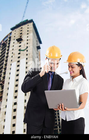 2 indian Engineer Colleague Concentration site Project Laptop Checking and talking phone Stock Photo