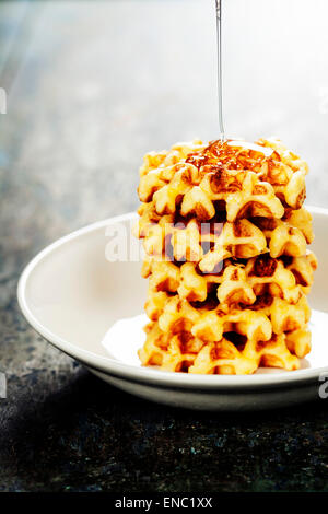 Waffles with honey on wooden table Stock Photo