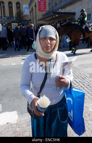 Young Roma woman begs for alms on the street of Gothenburg, Sweden Stock Photo