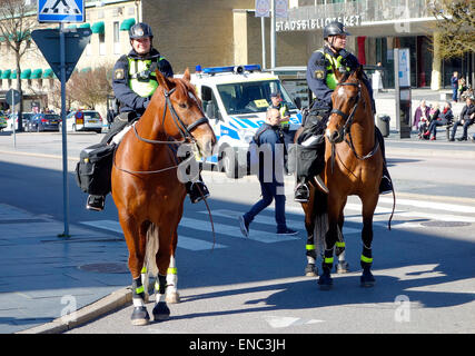Two mounted female Swedish police officers patrolling on the street of Gothenburg city, Sweden