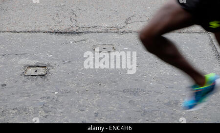 Leg and shoes of a 2015 Kenyan London Marathon competitor running along Upper Thames Street London UK KATHY DEWITT Stock Photo