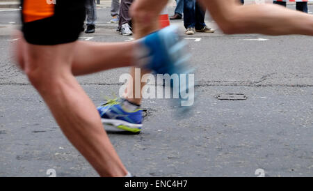 Blurred motion closeup blurry blur detail of legs shoe shoes of London Marathon runner runners competitor competitors wearing shorts running fast along Upper Thames Street with speed in the City of London UK   KATHY DEWITT Stock Photo