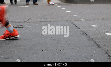 Detail of orange shoes of 2015 London Marathon competitor running along Upper Thames Street London UK KATHY DEWITT Stock Photo