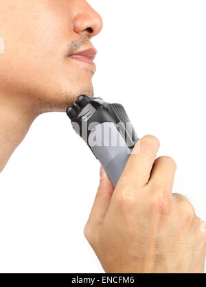 Young man shaving his beard off with an electric shaver Stock Photo