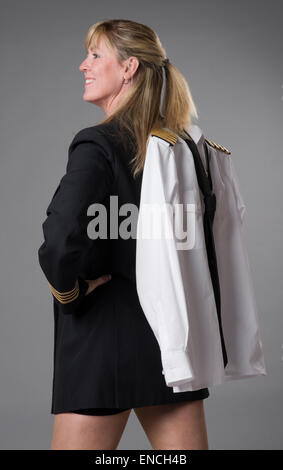 Attractive female airline officer wearing a short skirt and carrying her uniform jacket over the shoulder Stock Photo