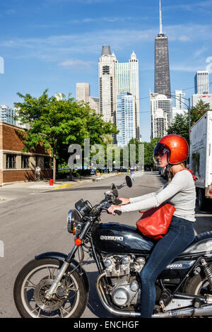 Chicago Illinois,North Side,Old Town neighborhood,community area,motorcycle,Suzuki,woman female women,stopped,helmet,red,matching handbag purse pocket Stock Photo