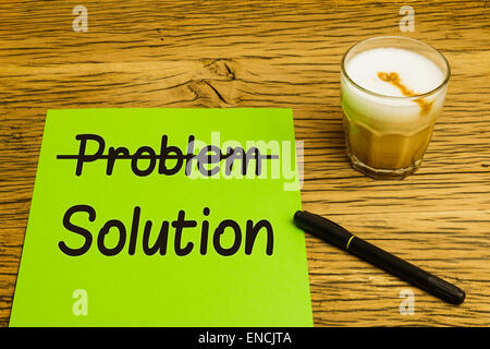 Business concept problem to solution with green page strikethrough text. Marker and coffee on oak desk. Stock Photo
