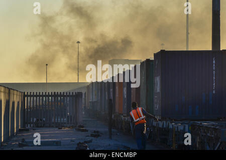 A worker at the container terminal of the port of Walvis Bay, Namibia, next to a freight train