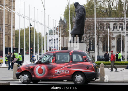 London Hackney Cab sponsored by Vodafone with the Statue of Winston Churchill in London England Stock Photo