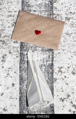 Love letter and paper toy plane at the runway asphalt Stock Photo