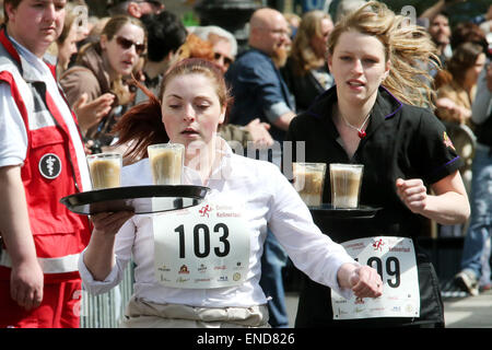 Berlin, Germany. 03rd May, 2015. Participants run with a tray during the annual Berlin run of waiters in Berlin, Germany, 03 May 2015. Waiters, barmen, chefs and pages compete in the art of the quick gastronomy. The 400 metres long running track stretches between the new Kranzler corner und Fasanen street. Photo: WOLFGANG KUMM/dpa/Alamy Live News Stock Photo