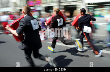 Berlin, Germany. 03rd May, 2015. Participants run with heavy luggage during the annual Berlin run of waiters in Berlin, Germany, 03 May 2015. Waiters, barmen, chefs and pages compete in the art of the quick gastronomy. The 400 metres long running track stretches between the new Kranzler corner und Fasanen street. Photo: WOLFGANG KUMM/dpa/Alamy Live News Stock Photo