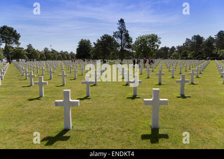 D-Day American Cemetery White Crosses in symmetrical rows with visitors at Coleville Cemetary, Omaha Beach, Normandy France Stock Photo